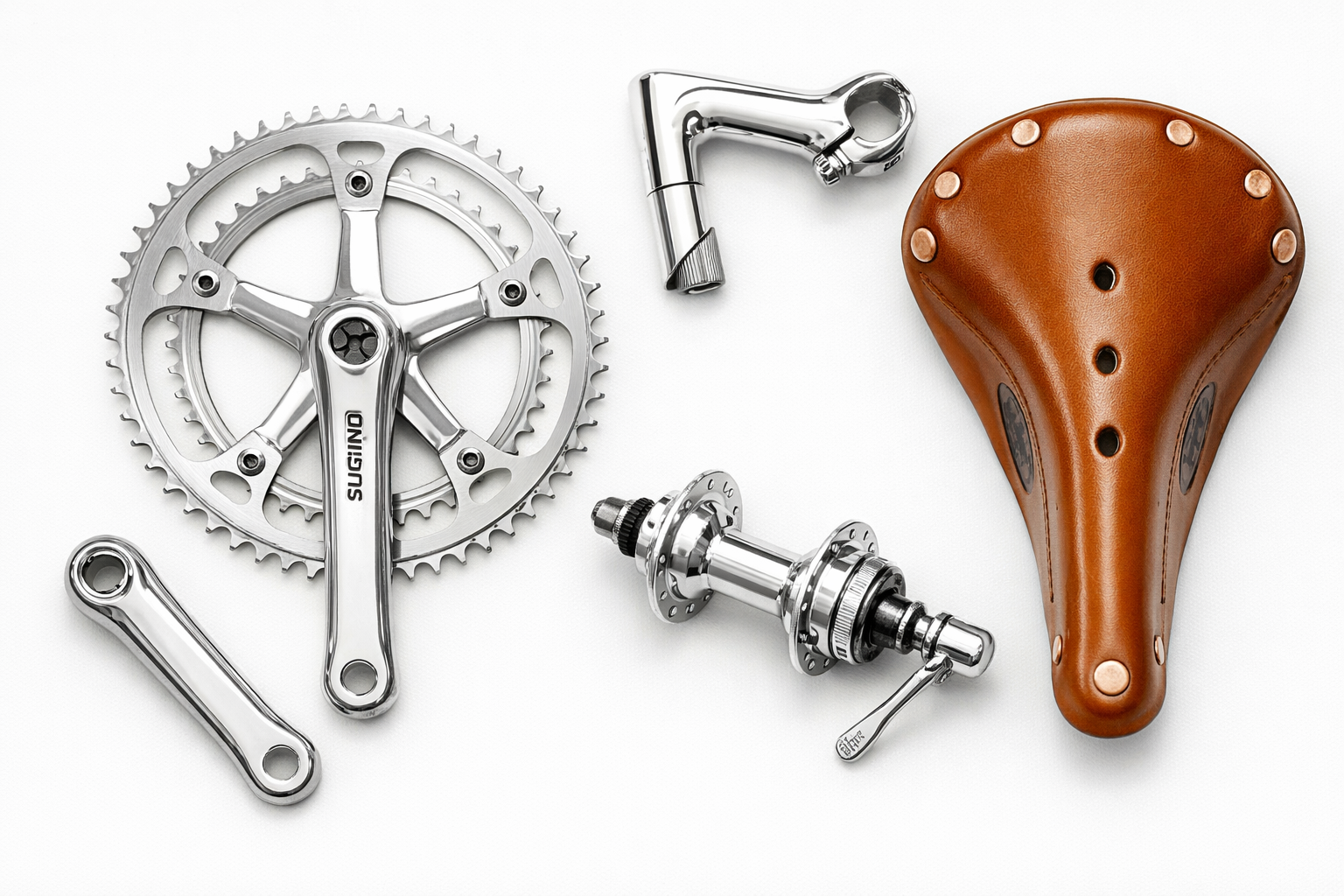 Flat lay of polished silver bicycle components: Sugino crankset, Nitto stem, Miche hub, Brooks leather saddle